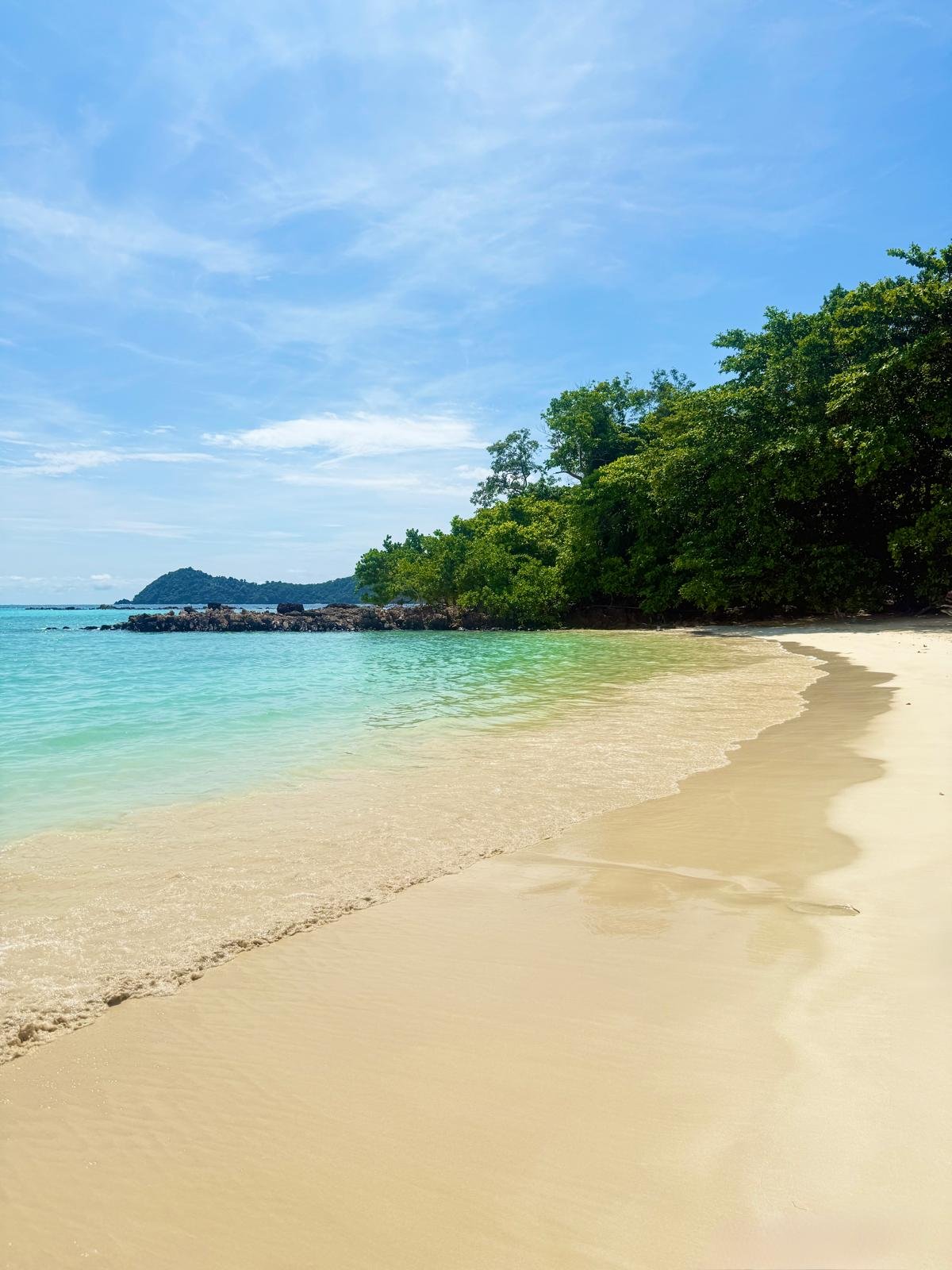 White sand and clear turquoise water in a quiet cove at Koh Lipe